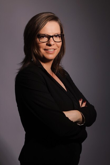 Foto retrato de una mujer de negocios con gafas contra un fondo gris