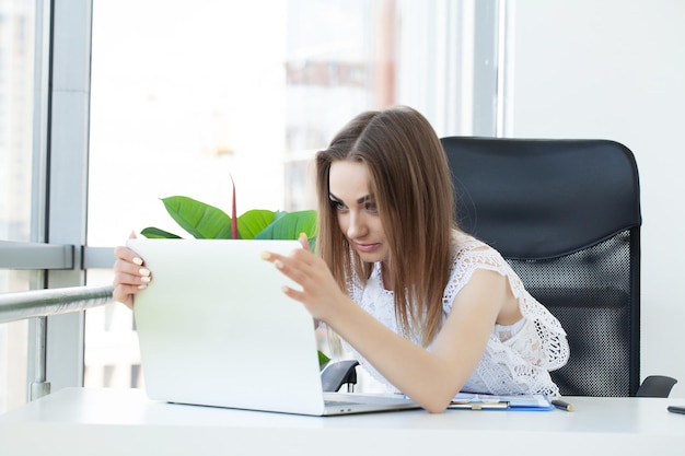 Retrato de mujer de negocios joven cansado con la computadora portátil