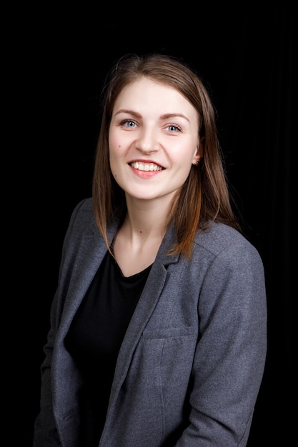 Retrato de mujer de negocios joven con una chaqueta gris.