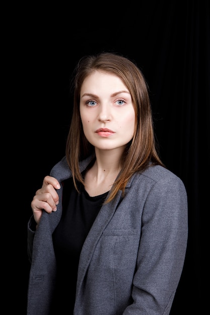 Retrato de mujer de negocios joven con una chaqueta gris.