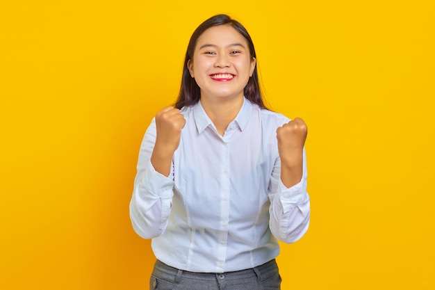 Retrato de mujer de negocios joven hermosa con rostro confiado emocionado y celebrando el éxito