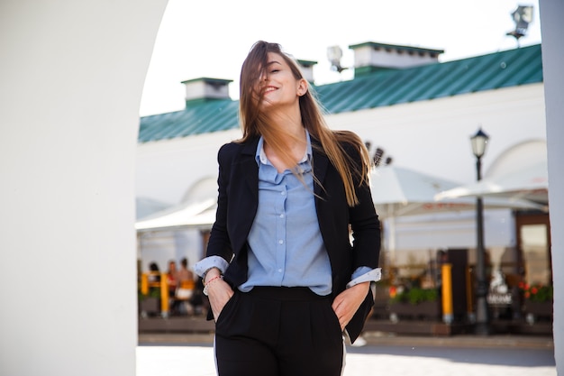 Retrato de mujer de negocios joven sonriente en traje con hermoso cabello largo.