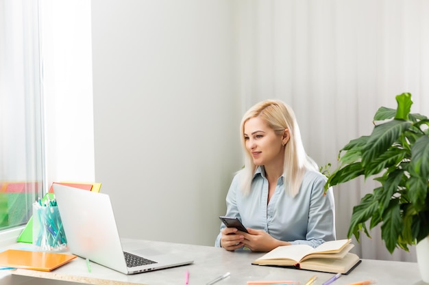 Retrato de una mujer de negocios madura concentrada trabajando en una computadora portátil mientras está sentado en la mesa en casa