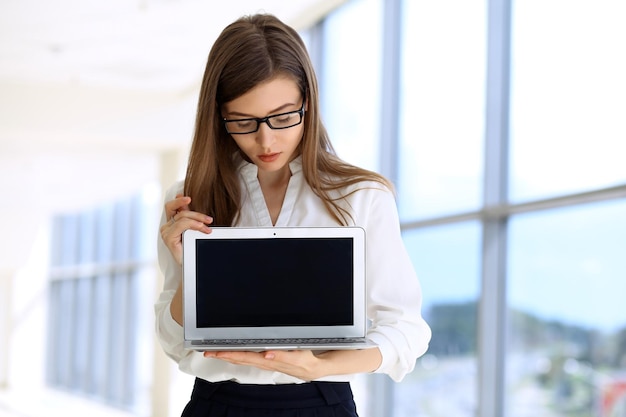 Retrato de una mujer de negocios moderna que trabaja con una computadora portátil en el área de espacio de copia de la oficina