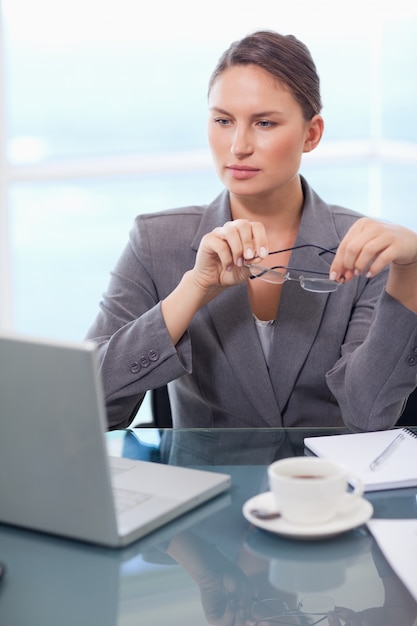 Retrato de una mujer de negocios poniendo sus gafas