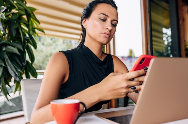 Retrato de una mujer de negocios que trabaja en una computadora portátil en el interior de un café