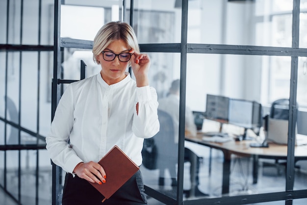 Retrato de mujer de negocios en ropa formal que se encuentra en la oficina.