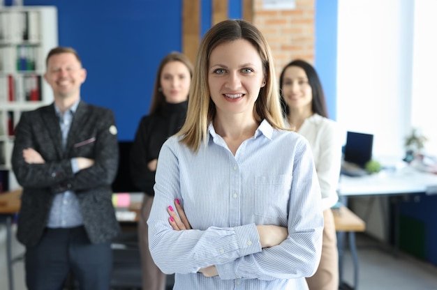 Retrato de mujer de negocios segura detrás del equipo empresarial