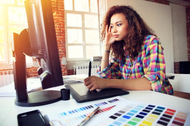 Retrato de una mujer de negocios seria que usa una computadora portátil en la oficina Hermosa mujer hipster tomando notas en la oficina moderna