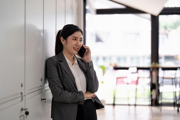 Retrato de una mujer de negocios sonriente y confiada sentada en la oficina y haciendo una llamada de negocios mientras trabaja