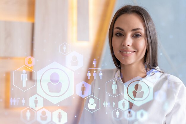 Foto retrato de una mujer de negocios sonriente con ropa formal que busca empleados y piensa en cómo contratar nuevos candidatos para consultoría de negocios internacionales iconos de redes de recursos humanos sobre los antecedentes de la oficina