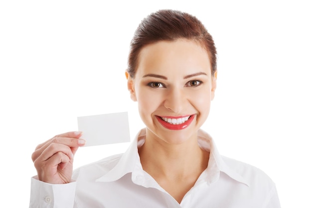 Foto retrato de una mujer de negocios sonriente sosteniendo una tarjeta de visita contra un fondo blanco