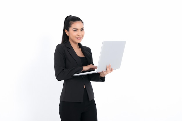 Retrato de mujer de negocios sosteniendo un portátil vistiendo un traje negro aislado en la superficie blanca