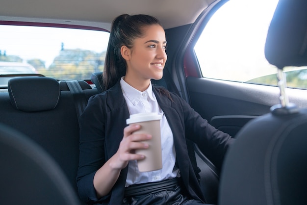Retrato de mujer de negocios tomando café en su camino al trabajo en coche. Concepto de negocio.