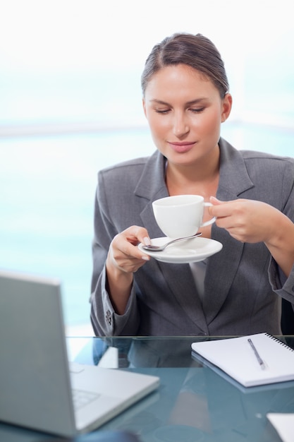 Retrato de una mujer de negocios tomando té