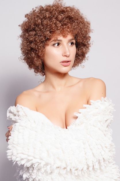 Retrato de mujer negra joven sonriente. Retrato de una bella mujer joven con corte de pelo afro afroamericano y maquillaje glamour. Tiro del estudio. Chica atractiva con anteojos