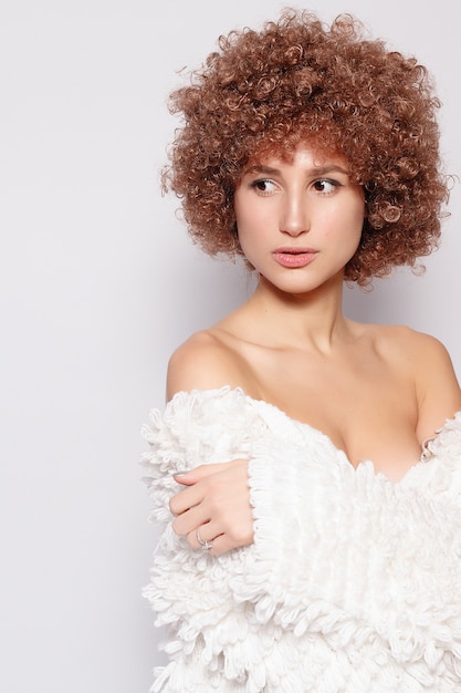 Retrato de mujer negra joven sonriente. Retrato de una bella mujer joven con corte de pelo afro afroamericano y maquillaje glamour. Tiro del estudio. Chica atractiva con anteojos