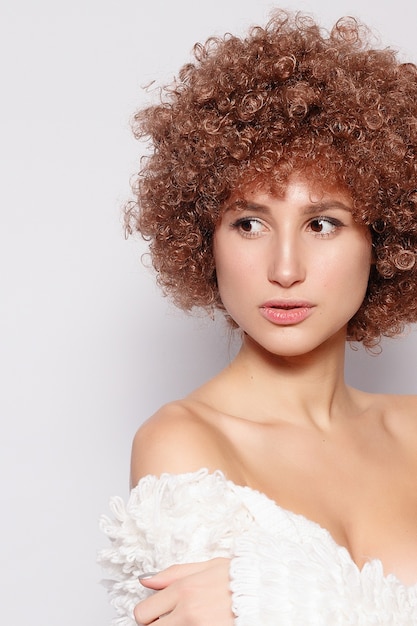 Retrato de mujer negra joven sonriente. Retrato de una bella mujer joven con corte de pelo afro afroamericano y maquillaje glamour. Tiro del estudio. Chica atractiva con anteojos.