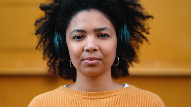 Retrato de mujer negra o auriculares de música sobre fondo amarillo aislado maqueta de moda o maqueta de pared Sonrisa feliz o estudiante riendo escuchando audio de radio y podcast en tela moderna o fresca