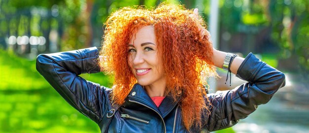 Retrato mujer niña cabello rojo sonrisa con dientes caminando en el bosque del parque al aire libre Sonriente mujer feliz cabello rojo rizado Retrato de hermosa niña pelirroja alegre volando cabello rizado sonriendo riendo