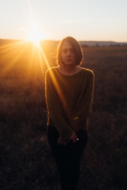 Retrato de una mujer en un paisaje contra el cielo al atardecer