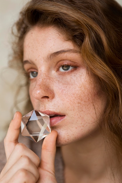 Foto retrato de mujer pecosa tapándose la boca con cristal