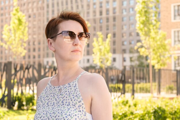 Retrato de una mujer pelirroja con un corte de pelo corto mujer con gafas de sol