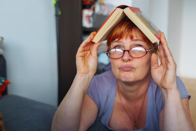 Foto retrato de una mujer pelirroja leyendo una novela