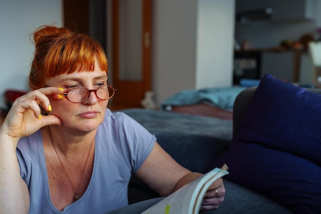 Foto retrato de una mujer pelirroja leyendo una novela