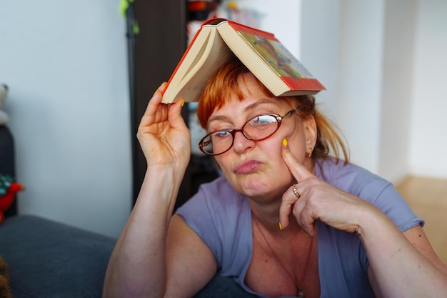 Foto retrato de una mujer pelirroja leyendo una novela