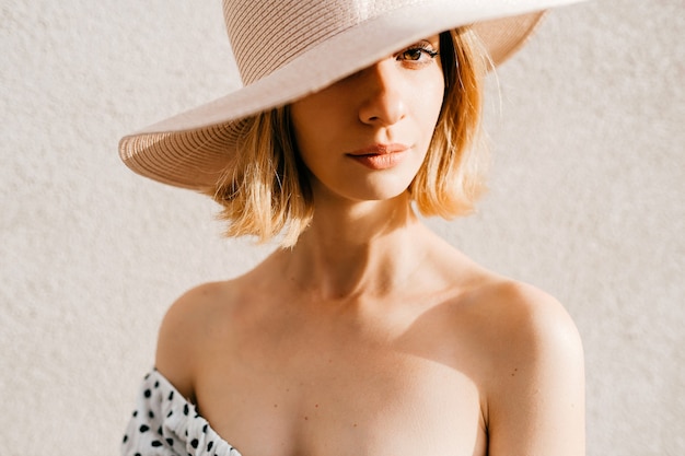 Retrato de mujer de pelo corto rubio elegante elegante con sombrero de cerca