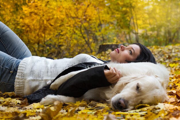 Retrato de mujer con perro en el parque otoño