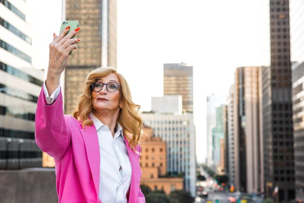 Retrato de una mujer de pie contra los edificios de la ciudad