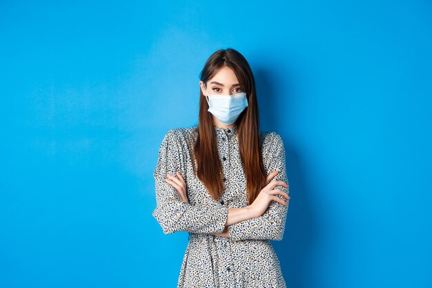 Foto retrato de una mujer de pie contra un fondo azul