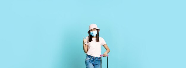 Foto retrato de una mujer de pie contra un fondo azul