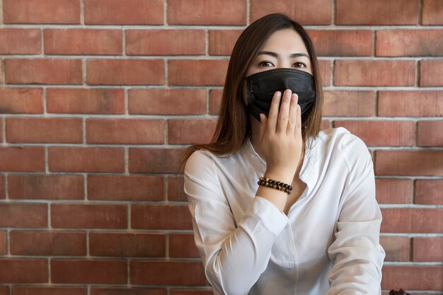 Retrato de una mujer de pie contra una pared de ladrillo