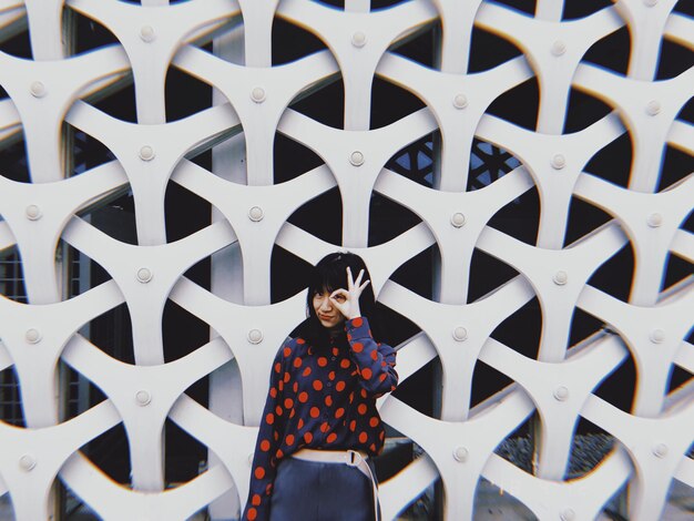 Foto retrato de una mujer de pie contra una pared con patrones