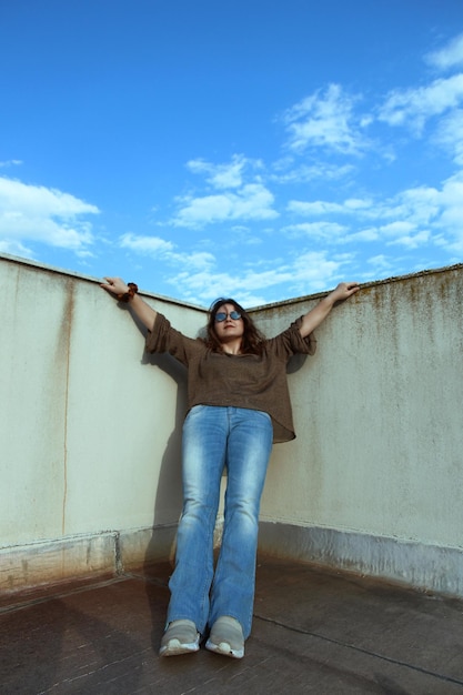 Foto retrato de una mujer de pie contra la pared