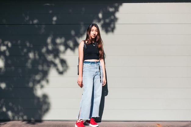 Foto retrato de una mujer de pie contra la pared