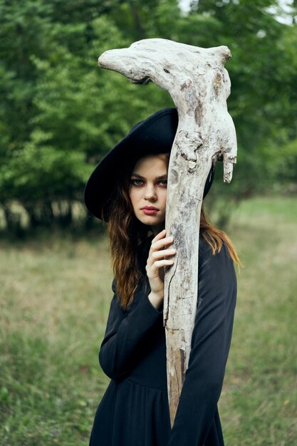 Foto retrato de una mujer de pie junto al tronco de un árbol