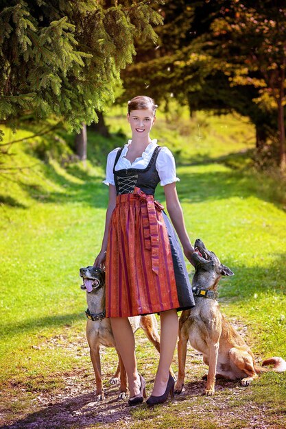 Foto retrato de una mujer de pie con perros en el parque