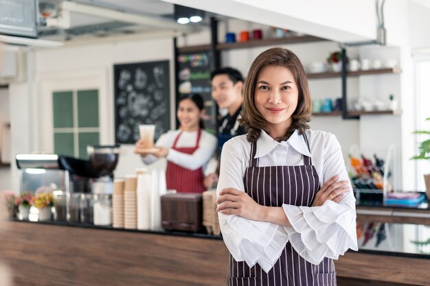 Retrato de mujer de pie en su cafetería.