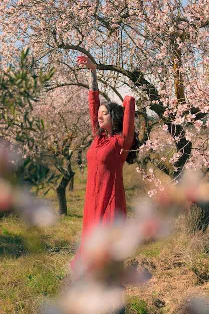 Retrato de una mujer posando con un almendro y un ambiente primaveral