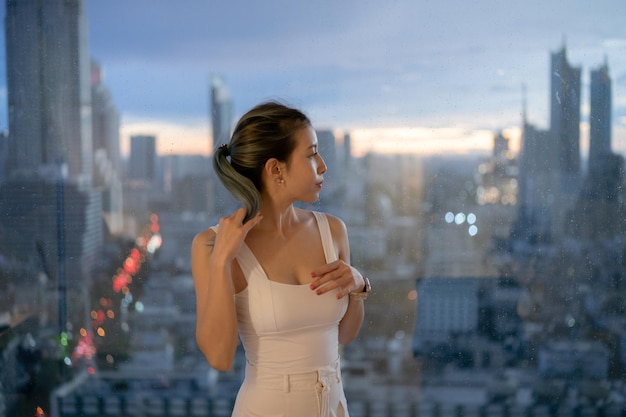 Retrato mujer posando en el balcón con vistas a la ciudad