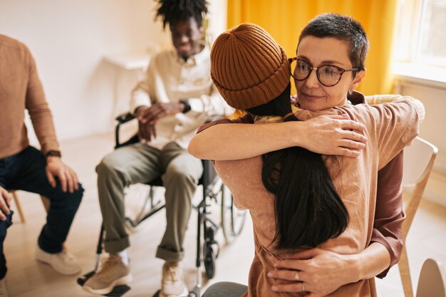 Foto retrato de mujer psicóloga abrazando a una mujer joven durante la sesión de terapia en el grupo de apoyo, espacio de copia