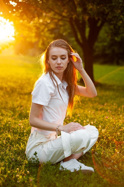 retrato de mujer en la puesta de sol cerca del árbol