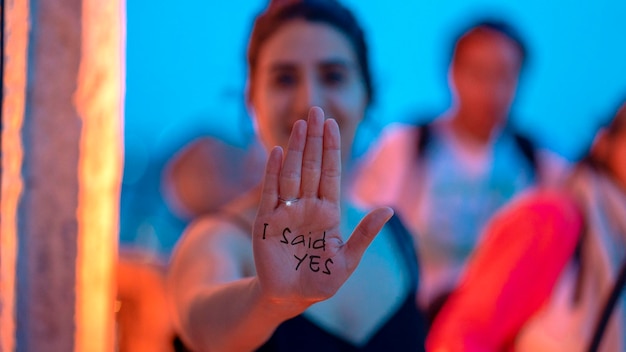 Foto retrato de una mujer que muestra texto en la palma de la mano