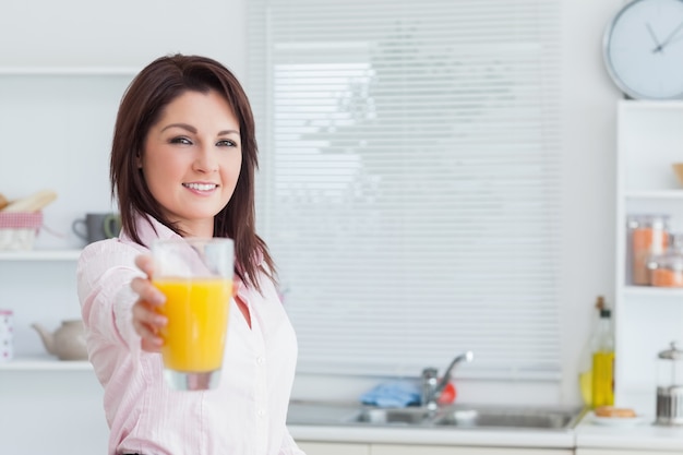 Retrato de mujer que le ofrece jugo de naranja