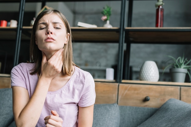 Foto retrato de una mujer que sufre de dolor de garganta.