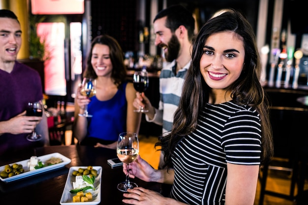 Foto retrato de mujer que tiene un aperitivo con amigos en un bar